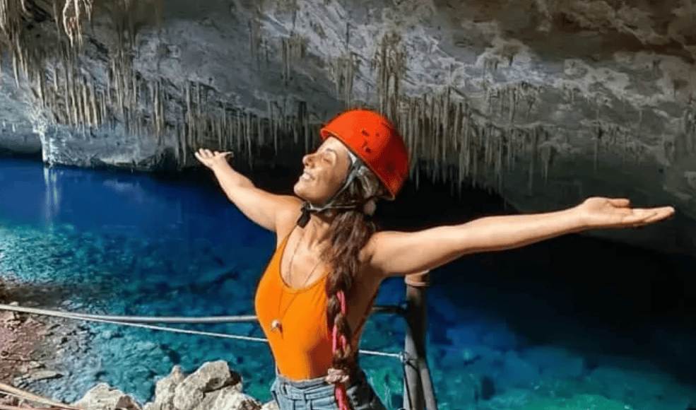 Visitante com capacete diante do lago azul no interior da Gruta do Lago Azul em Bonito MS